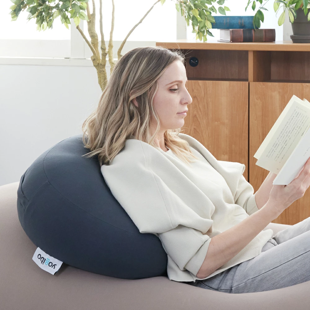 ヨギボーマックスの上にヨギボーメガムーンピローをのせ、背もたれにして読書している人の画像